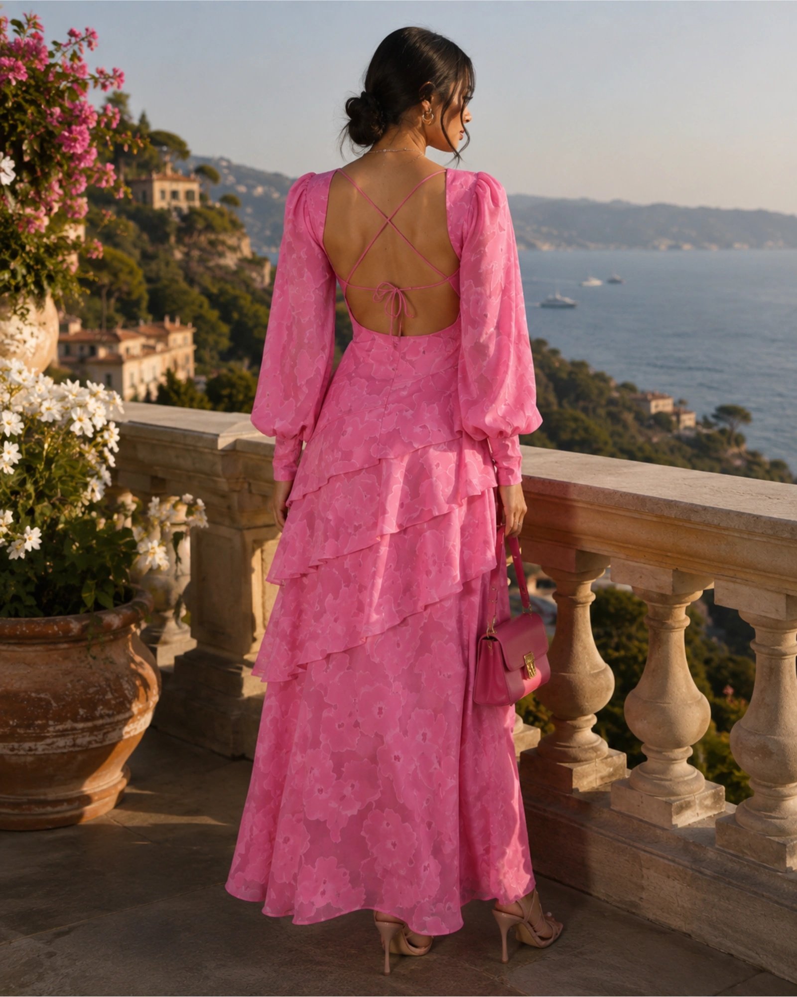 Μοντέλο με ροζ jacquard maxi φόρεμα Pretty Lavish σε πολυτελές εξωτερικό χώρο με θέα στη θάλασσα