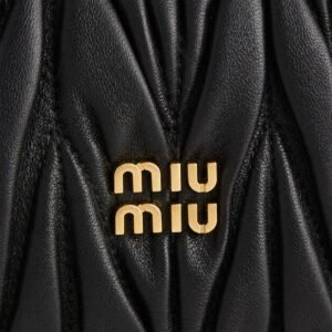 Λεπτομέρεια χρυσόχρωμου λογότυπου Miu Miu σε μαύρο δέρμα Matelassé