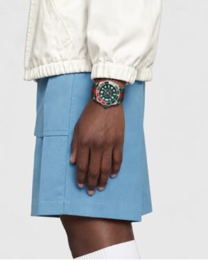 Gucci Dive YA136339 ρολόι με πράσινο καντράν και κόκκινο πράσινο Web λουράκι φορεμένο στον καρπό μοντέλου
